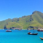 Labuan Bajo coastal view with boats and hills.