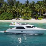 Yacht charter in Indonesia with tropical island backdrop.