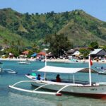 Labuan Bajo harbor with boats and green hills.